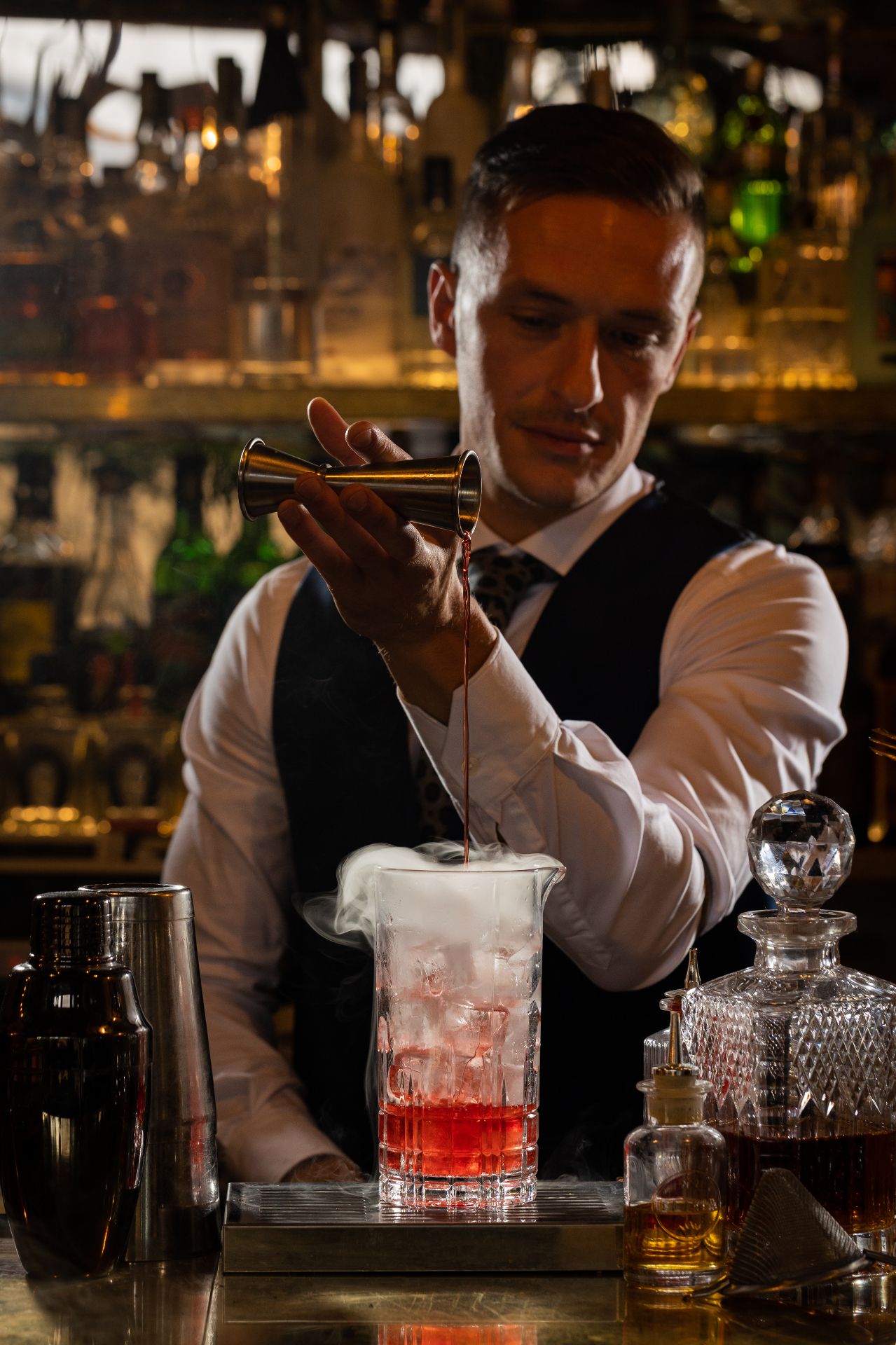 Bartender versa un cocktail rosso fumante
